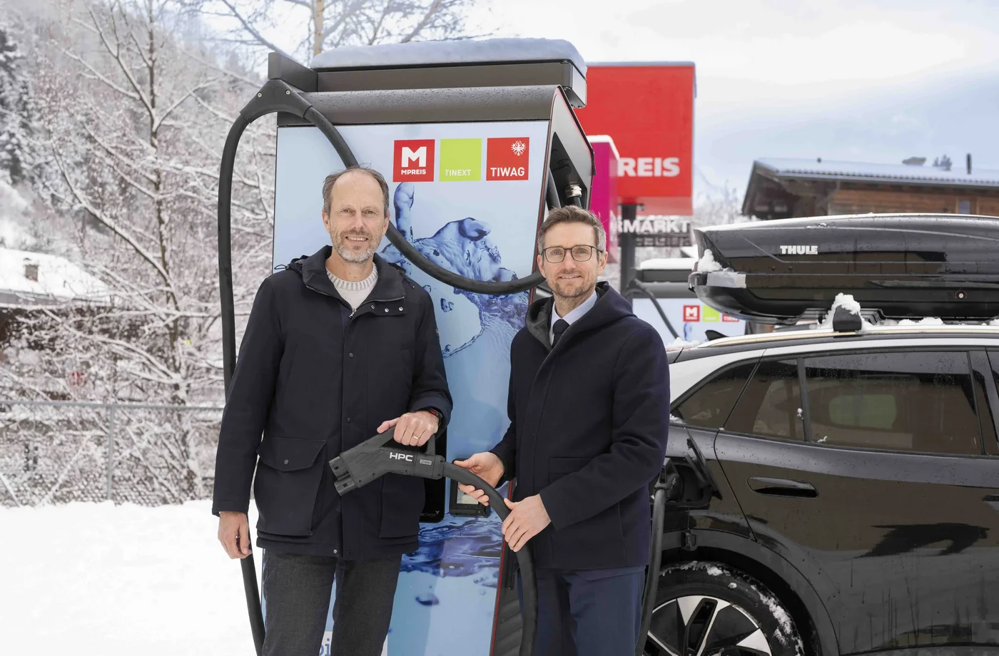 MPREIS-Geschäftsführer David Mölk und TIWAG-Vorstand Michael Kraxner (r.) vor einer E-Ladesäule bei der MPREIS-Filiale in Fulpmes.